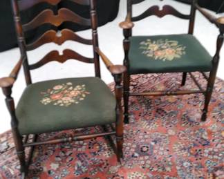 Antique ladderback arm and rocking chair with needlepoint seat coverings.