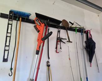 Garage Wall Tool Rack with Assorted Long-Handled Tools and Yard Equipment - Great for organized vertical storage in a workspace or garage.