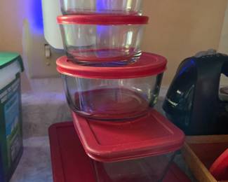 A practical collection of round and square clear glass containers, each paired with a snug-fitting red plastic lid. Ideal for leftovers, meal prep, or pantry organization. Stackable design makes for easy storage in the fridge or cupboard.