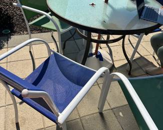 #55 - $150 - Patio assorted 42x30 table & 6 multicolor chair & tiki umbrella
