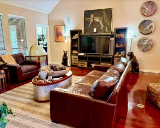LARGE DEN WITH UPSCALE LEATHER FURNITURE, LARGE CERAMIC CHARGERS, BRONZES, WOODEN BOXES, AND MORE.