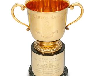 2068
1987
A Santa Anita Park "San Carlos Handicap" horse racing trophy
Underside marked: O. C. Tanner / Kirk Stieff / Sterling / Silver; exterior marked: San Carlos Handicap / [shield / Santa Anita Park; base inscribed: February 1, 1987 / One Mile and One-Sixteenth / Won by / Epidaurus / Howard B. Keck, Owner / Charles Wittingham, Trainer / William Shoemaker, Jockey / Time 1:42:2
The gilt sterling silver trophy with opposed scrolled handles and gadrooned foot, set on a marble tiered base with a metal plaque
2 pieces
Trophy: 5.5" H x 8.125" W x 5" D; Base: 4.75" H x 4.75" Dia
19 oz. troy approximately
Estimate: $700 - $900