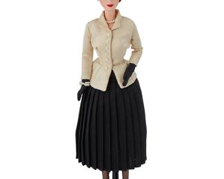 2104
Christian Dior Limited Edition 50th Anniversary 1947 "New Look" Barbie Doll
Circa 1996/1997; Mattel, Inc.; with Christian Dior tag to skirt interior: © 1995
A licensed reproduction featuring a brunette Barbie® with blue eyes, wearing a replica of a famous New Look ensemble including a beige tailored jacket with a narrow waist with a full black pleated skirt, accessorized with a broad straw hat, pearl bracelet, necklace and earrings, as well as black gloves, a lacy black petticoat and underwear including black stockings and a garter belt, and black stiletto pumps, with associated stand
12.5" H x 3" W x 3.5" D (hat)
Estimate: $150 - $250