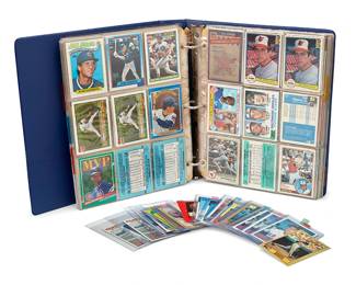 2055
A Group of Baseball Cards
Late 20th century
Comprising approximately 502 mostly Topps baseball cards arranged in 35 plastic pages held in a ring binder, together with 17 single baseball cards, most in plastic sleeves, including players such as Nolan Ryan, Lou Whitaker, Dale Murphy, Dwight Gooden, Will Clark, Steve Howe, Jose Canseco, Ryne Sandberg, Cal Ripken, Cal Ripken, Jr., Don Mattingly, Wade Boggs, Mark McGwire, Roger Clemens, Lou Piniella, and Omar Moreno, many with multiple duplicates, as well as five Topps Star Wars cards, four in sleeves, 524 pieces approximately
Each card: 3.5" H x 2.5" W
Estimate: $300 - $500