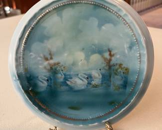 Vintage porcelain plate or lid featuring a hand-painted scene of five swans on a lake.