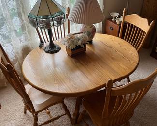 Oak dining table with four chairs and four leaves.
