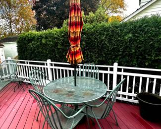 Heavy wrought iron table and chairs, sunbrella umbrella.