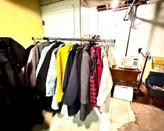 Two racks filled with women's coats and vests.
