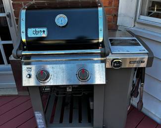Weber Genisis 2 gas grill with cover and utensils.