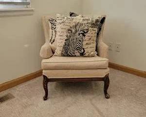 Cream Upholstered Tufted Accent Chair with Carved Wood Legs and Zebra Print Decorative Pillow