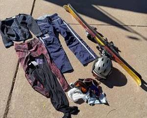 K2 Classic Yellow Woodgrain Skis with Black and Red Bindings, Smith Black Helmet, Blue Ski Pants, Patterned Ski Apparel, and Ski Goggles