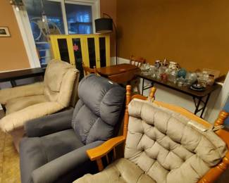 Quite a few large rocking chairs, glassware, another bookcase and table