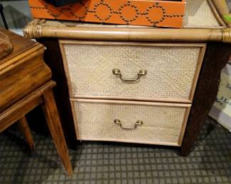 rattan chest of drawers, orange tray, crewel needle work picture of flowers and squares