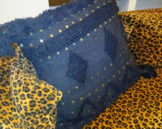 oversized black woven decorative African inspired pillow on leopard print velvet sectional sofa