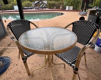 Small patio table with two chairs, some outdooor wear and damage