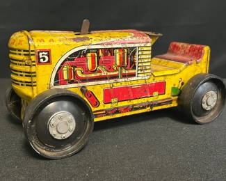 Vintage 1953–1956 Louis Marx & Co. No. 5 Tin Bulldozer Wind-Up Toy
A colorful slice of 1950s mechanical imagination — this Louis Marx No. 5 Bulldozer features bold yellow lithography, detailed “engine-cutaway” side graphics, and sturdy post-war construction. The toy reflects Marx’s golden era of American tin-toy manufacturing, blending playful engineering with industrial-age design.

• Stamped MARX 5 across rear panel
• Bright yellow & red body with multicolor engine illustration
• Lever-operated wind-up action (untested for function)
• Original black pressed-steel wheels
• Approx. 7 ½" L × 3 ¾" H
• Age-consistent scuffs & edge wear; retains strong color & graphics
