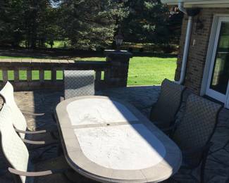 TROPITONE OVAL STONE TABLE WITH SIX CHAIRS 
TWO SWIVEL AND FOUR ROCKERS