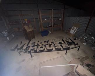 Huge neon sign, MERCHANT HOUSE. One letter is missing a small section of glass tube