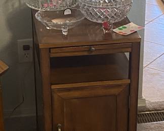 Tall chair-side table with storage,  pull-out shelf.  
Also shown,  various crystal items.