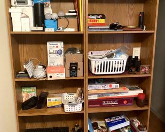 Various office supplies and games. 
Top left shelf has a bunch of Echo dots and plugs to control outlets with Alexa.