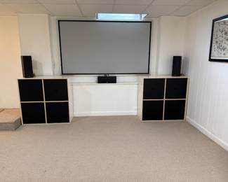 102 inch screen for home theater, and storage units.  Some of the speakers for the system.