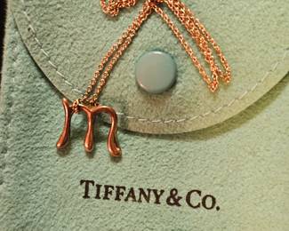 M charm on necklace by Tiffany.
