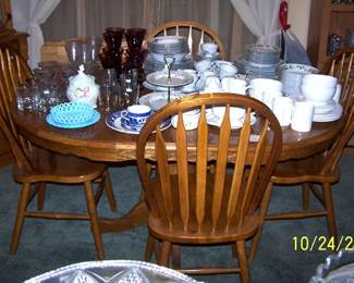 Oak pedestal table, one leaf, four chairs, china and glassware
