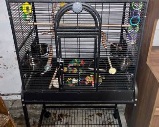 Large bird cage with lots of toys and accessories