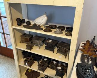 Cast Iron Banks: Coronation red crown, Taj Mahal, Horse, Camel, Lion, Dog. White goose doorstop, WWI hat paperweights, Barbells, Miniature wood cookstoves, Rotating nail holder, Ink well.