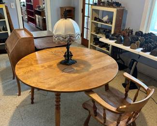 Round solid maple kitchen table with 3 leaves. Captains chair, maple. Cast Iron lamp with beaded shade.