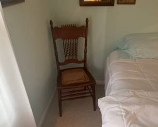 A matching pair of oak cane chairs as is