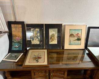 Wooden coffee table with protective glass top and framed wall art