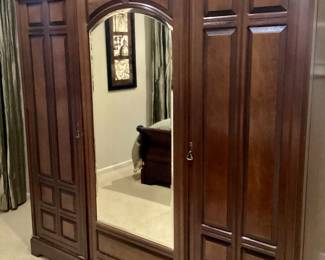 Armoire double doors open up to drawers and shelves. One door opens up to glass shelves.