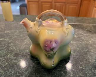 RS Germany Hand-Painted Art Nouveau Porcelain Vase (c. 1900). Picture 1 of 2. Antique RS Germany porcelain vase designed in a whimsical teapot form with flowing Art Nouveau curves and molded relief details. Hand-painted thistle florals with soft airbrushed pastel shading. Marked on the underside with the RS Germany green crest.
Beautiful collector’s piece for curio cabinets, Victorian décor, or Art Nouveau displays.
Dimensions: approx. 6–7” tall
Condition: Excellent antique condition with expected light wear. 
Price: $125                                                                                                          First Day Sale: $95