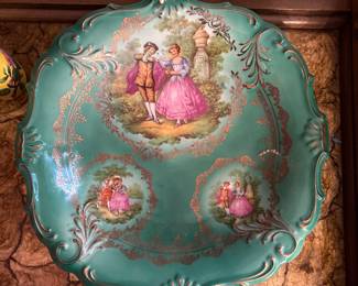 Vintage Bavarian Decorative Cabinet Plate (Turquoise Rococo Courting Scene) Picture 1 of 2
Vintage porcelain display plate with romantic courting couple scenes, turquoise ground, and gilt scrollwork. Features multiple reserve vignettes and ornate relief-molded rim. Marked on reverse with Schönhammer Bavaria stamp. Equipped with plate hanger for wall display.
Beautiful collector/display piece.
Very good vintage condition.                                                                                 
Pricing: $30 or BO