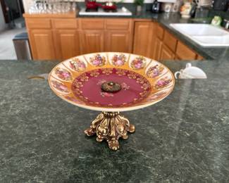 Vintage Porcelain & Gilt Metal Compote
Romantic courting scene transfer panels with rich gold scrollwork and a deep cranberry center, mounted on an ornate cast gilt base. Excellent decorative accent for vanities, foyers, or serving wrapped chocolates. Beautiful vintage patina.
Price: $105
