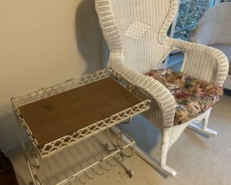 A metal planter/table with wicker rocker.