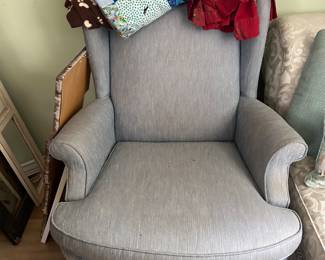 A gently used wing chair ready for a user armed with a comfy throw snd good book or magazine.