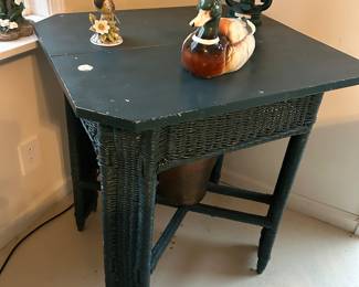 Unusual wicker table with ceramic duck, lantern and figurine.