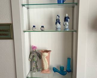 A Shirley Temple mini pitcher, upper right, along with a worry/stress doll, lower left, shown with a blue couple made in Occupied Japan, Fenton- inspired blue glass, pretty shakers and an unusual peach-colored vase.
