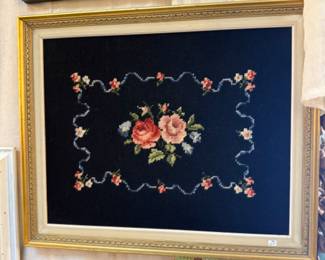 beautiful floral cross stitch in antique frame on black background