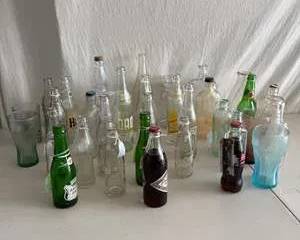 Vintage Coca-Cola and Soda Pop Glass Bottles with Assorted Clear, Green, and Colored Bottles and Glasses
