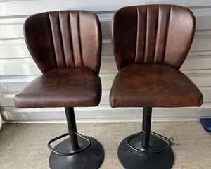 Pair of Brown Faux Leather Swivel Bar Stools with Black Metal Bases and Vertical Stitching