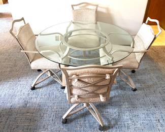 Vintage glass top table with 4 matching cushioned chairs on rollers