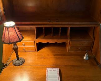 Elegant drop-front secretary desk in a warm cherry finish. Features multiple small drawers, cubby organizers, and a spacious upper hutch for display or storage.