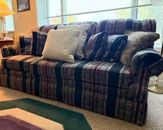 Traditional upholstered sofa featuring a deep plaid pattern in rich tones of green, burgundy, and gold.