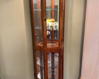 - Tall curio cabinet with glass shelving, cherry finish