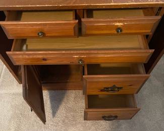 C6 - $50. Sewing Machine Table. Measures 33" wide x 24" deep x 28" tall. Each leaf adds 24". There is wear on the surface. Cabinet has 5 drawers, 1 door on hinges. (Needs minor work to reattach one leaf.)