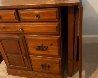 C6 - $50. Sewing Machine Table. Measures 33" wide x 24" deep x 28" tall. Each leaf adds 24". There is wear on the surface. Cabinet has 5 drawers, 1 door on hinges. (Needs minor work to reattach one leaf.)