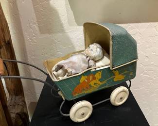 Tiny antique tin baby carriage with bisque baby doll